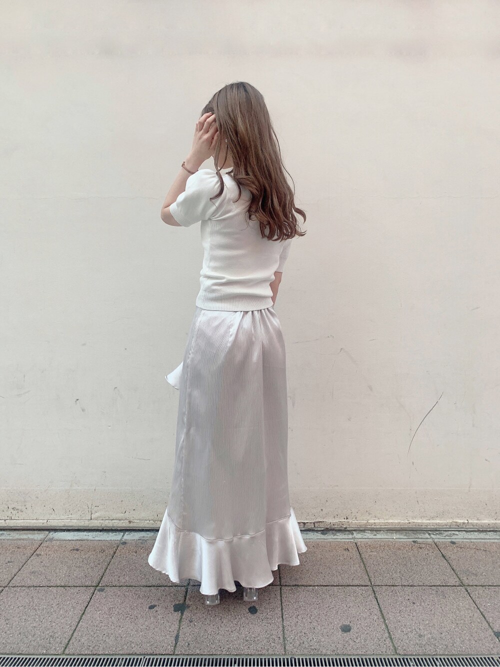 グレー系のスカート、ブルー系のサンダル、ホワイト系のニット/セーターを着用したレディースの春コーディネートの5枚目の写真