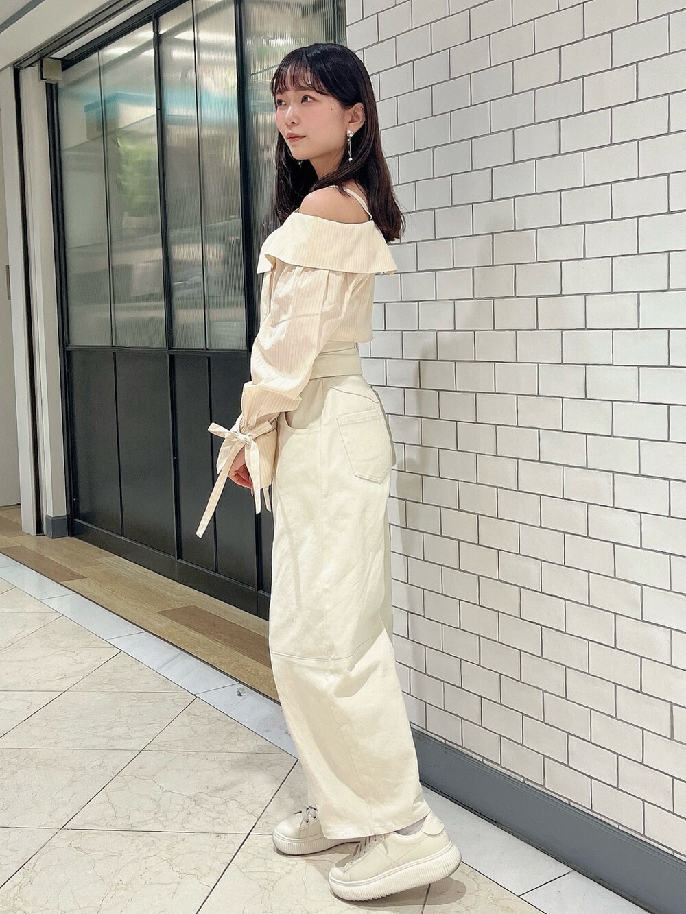 イエロー系のシャツ/ブラウス、ホワイト系のデニムパンツを着用したレディースの春コーディネートの3枚目の写真