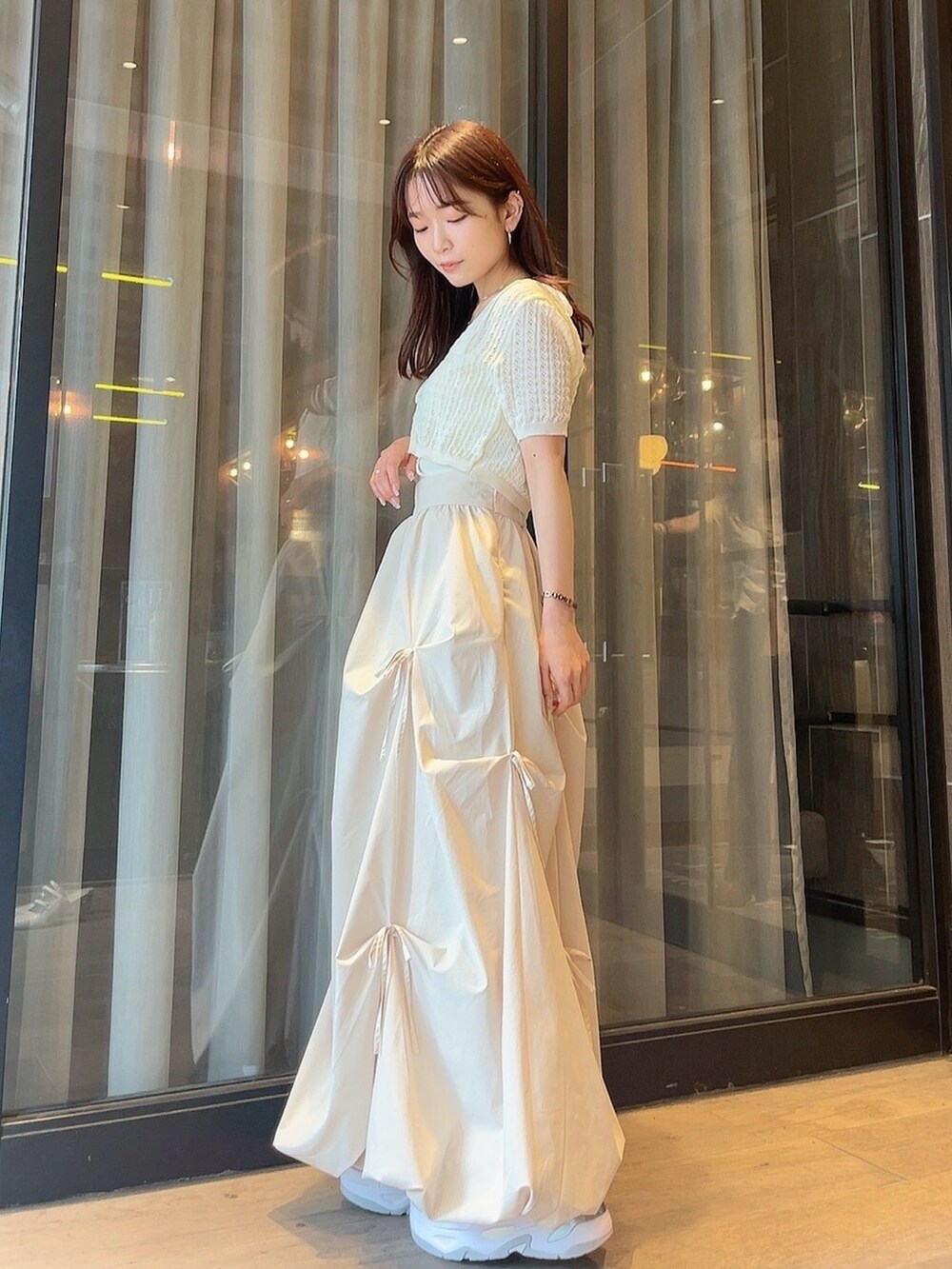 ホワイト系のニット/セーター、ホワイト系のスカートを着用したレディースの夏コーディネートの2枚目の写真