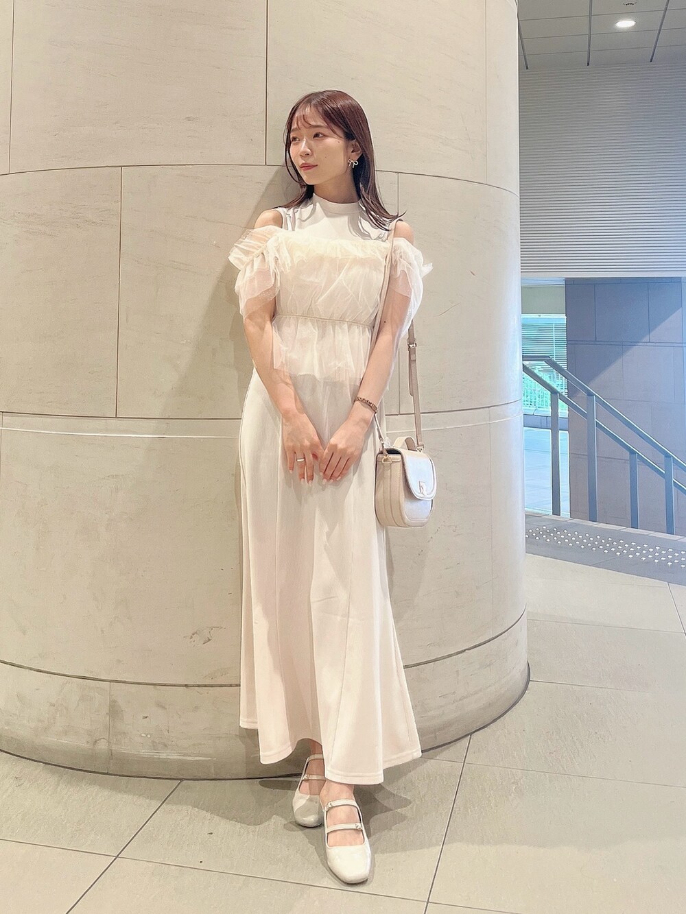 ホワイト系のワンピース、ホワイト系のパンプス、ホワイト系のハンドバッグを着用したレディースの夏コーディネートの2枚目の写真