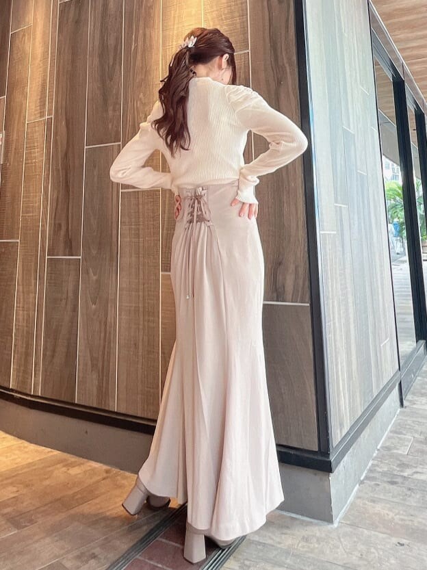 ベージュ系のブーツ、ベージュ系のスカート、ホワイト系のニット/セーターを着用したレディースの秋コーディネートの7枚目の写真