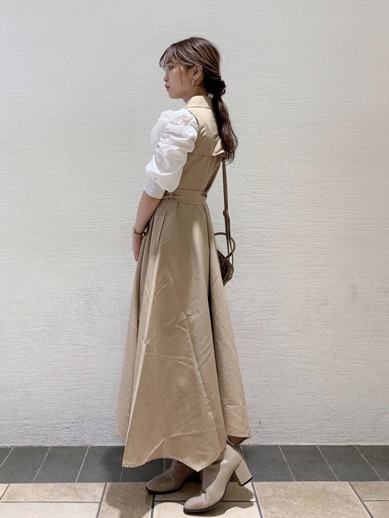 ベージュ系のワンピース、ベージュ系のブーツ、ホワイト系のニット/セーターを着用したレディースの秋コーディネートの2枚目の写真