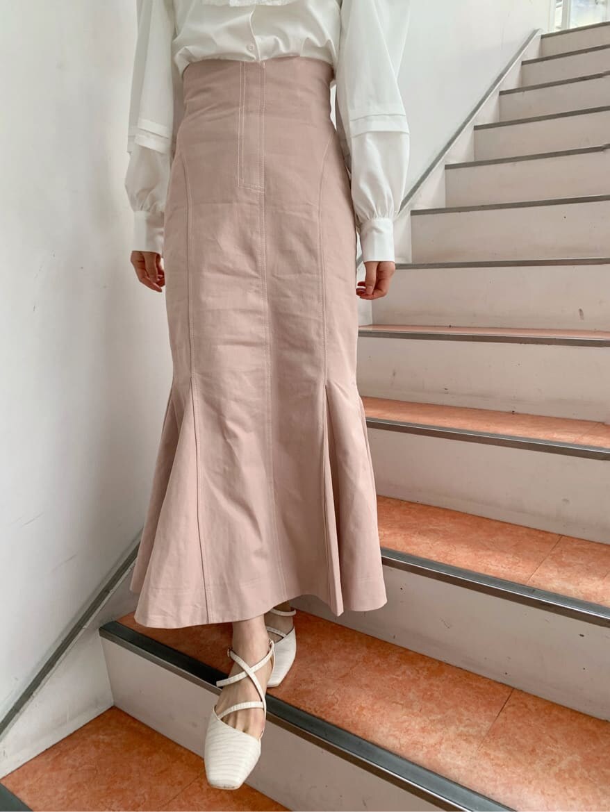 ホワイト系のパンプス、ホワイト系のシャツ/ブラウス、ピンク系のスカートを着用したレディースの冬コーディネートの9枚目の写真