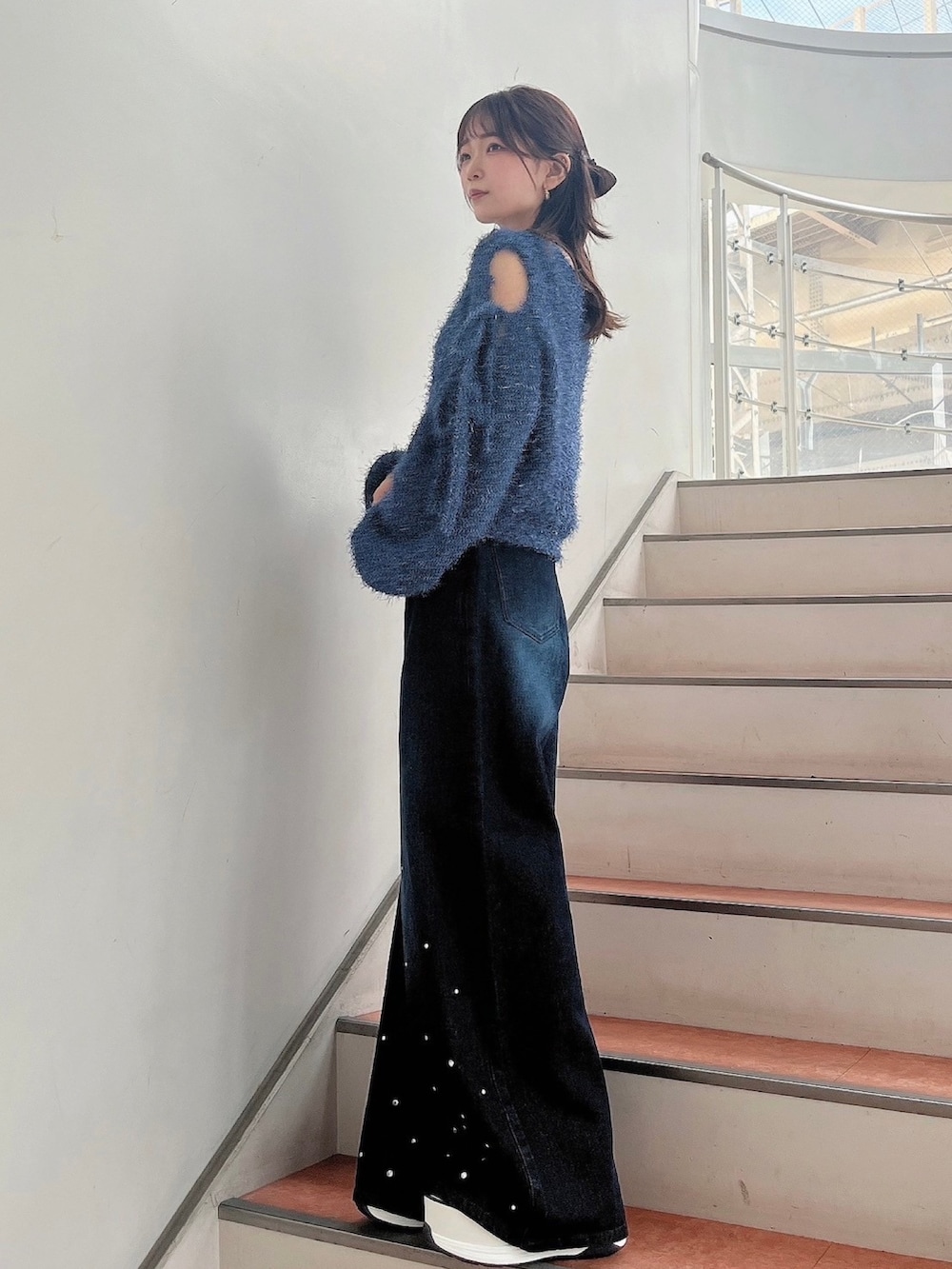 ブルー系のニット/セーター、ブルー系のデニムパンツ、ホワイト系のサンダルを着用したレディースの夏コーディネートの6枚目の写真