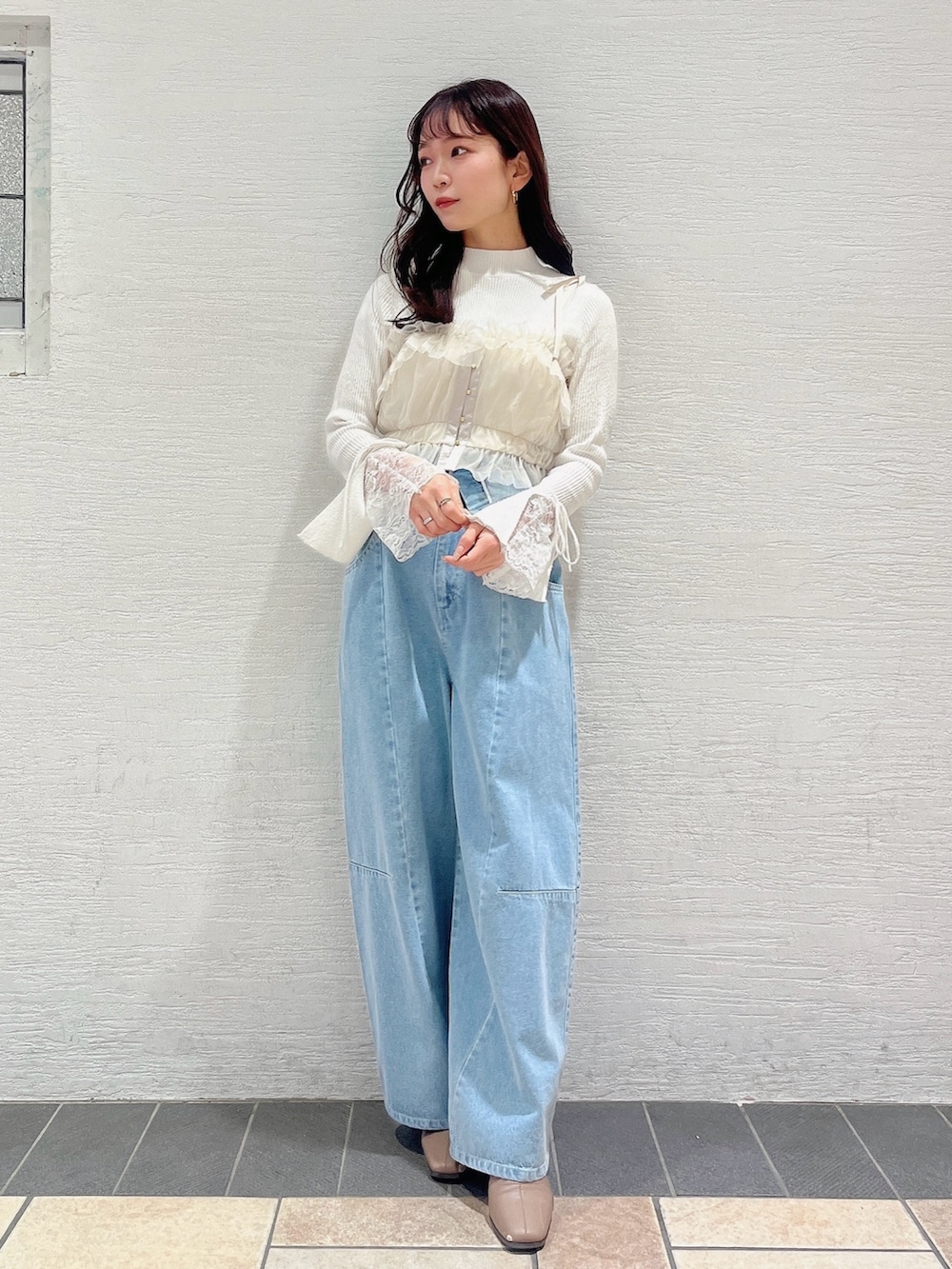 ベージュ系のブーツ、ブルー系のデニムパンツ、ベージュ系のキャミソールを着用したレディースの冬コーディネートの2枚目の写真