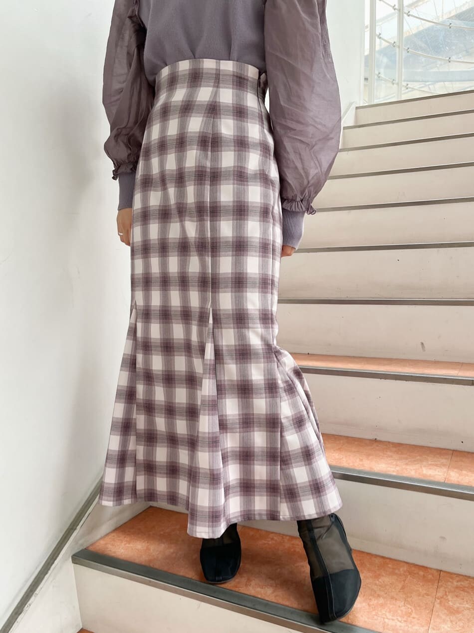 ブラック系のブーツ、パープル系のニット/セーター、パープル系のスカートを着用したレディースの冬コーディネートの7枚目の写真