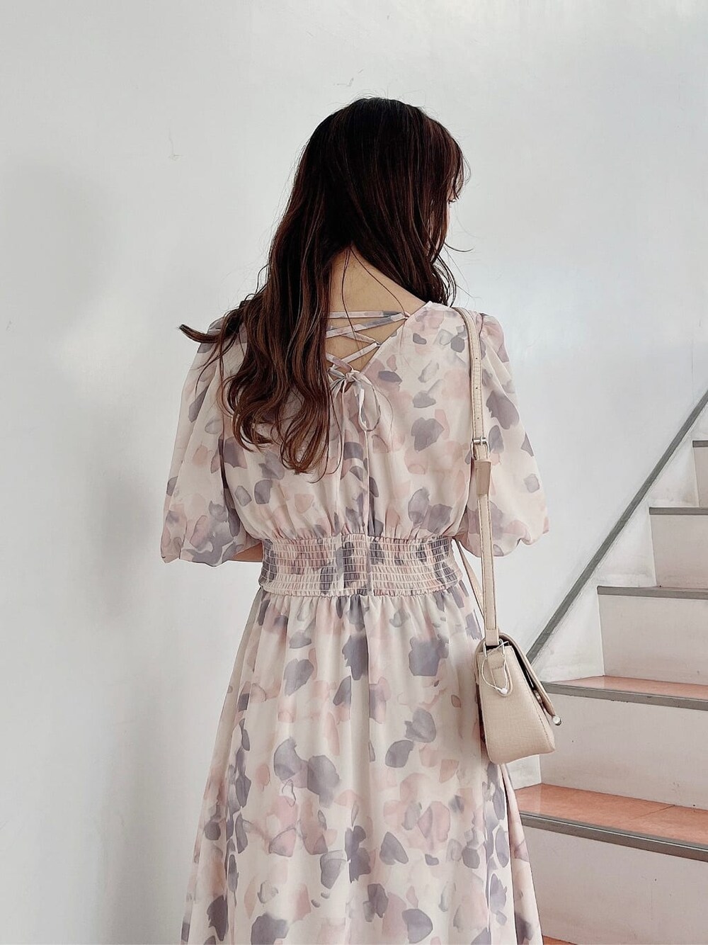 ピンク系のワンピース、ホワイト系のパンプス、ベージュ系のショルダーバッグを着用したレディースの春コーディネートの5枚目の写真