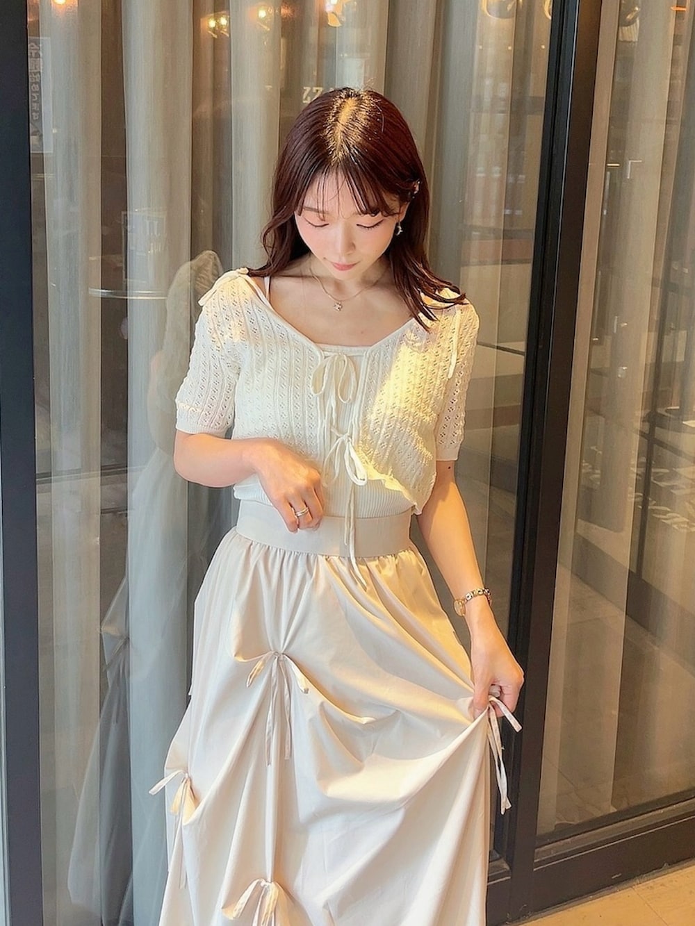 ホワイト系のニット/セーター、ホワイト系のスカートを着用したレディースの夏コーディネートの5枚目の写真