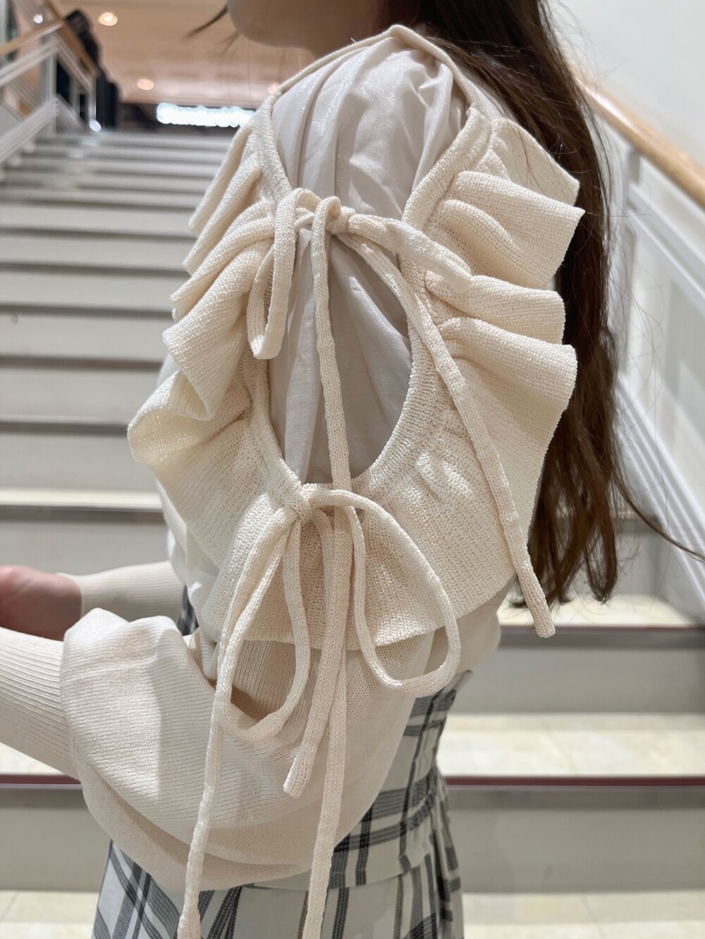 ホワイト系のニット/セーター、ホワイト系のスカート、ベージュ系のブーツを着用したレディースの冬コーディネートの9枚目の写真