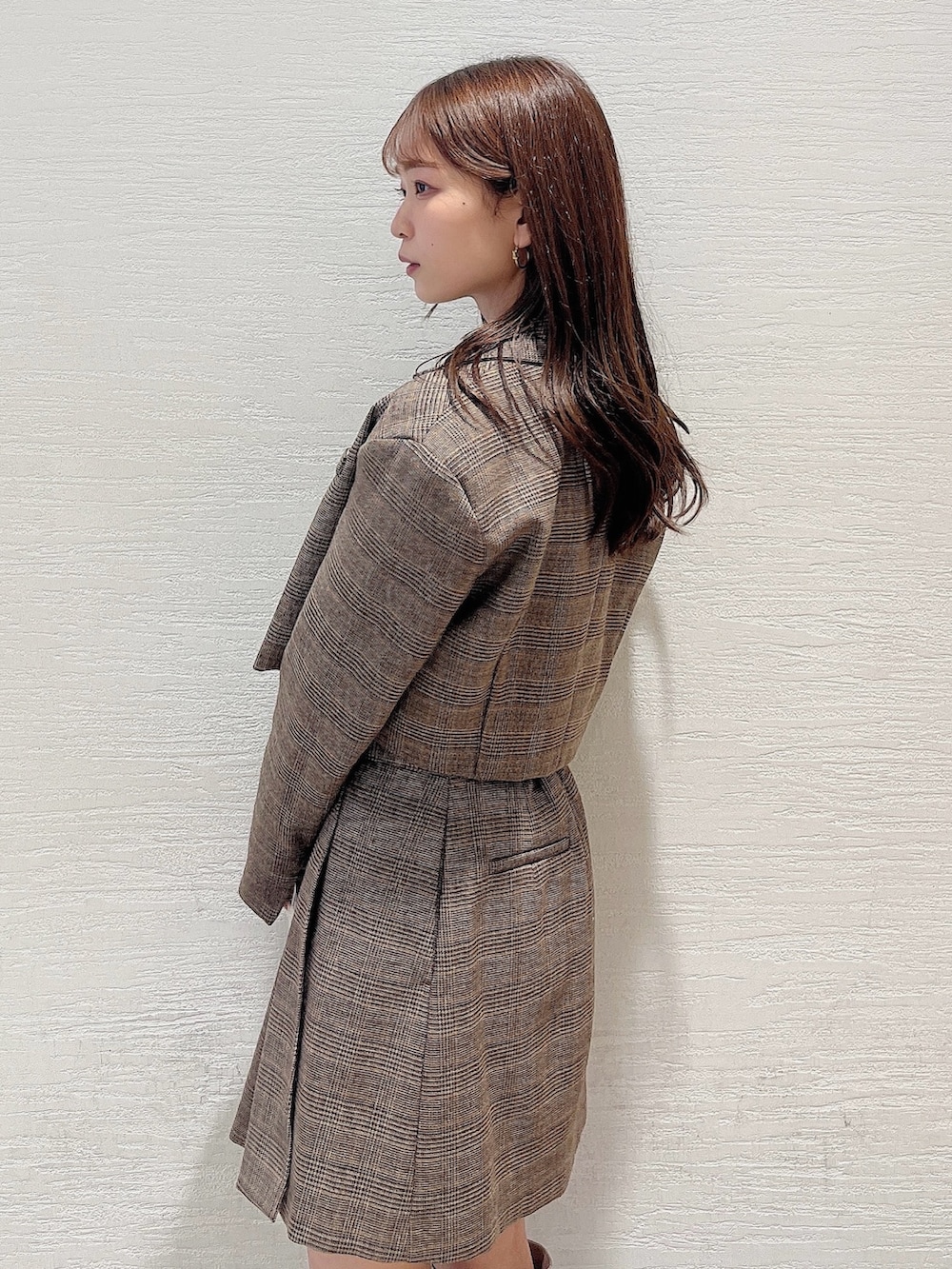 ベージュ系のブーツ、ブラウン系のスカート、ホワイト系のニット/セーターを着用したレディースの秋コーディネートの7枚目の写真