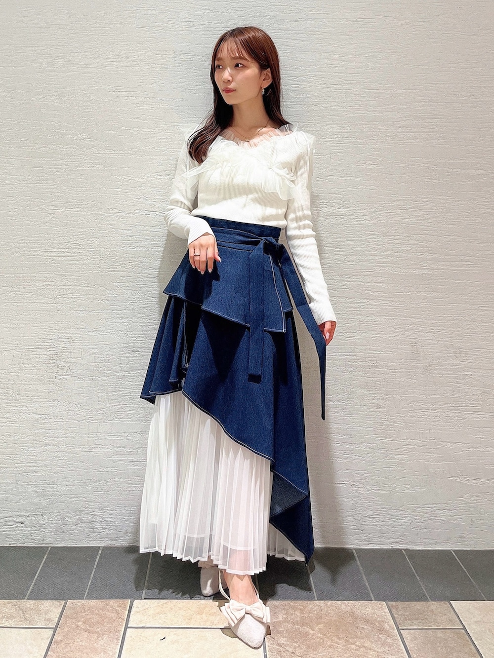 ベージュ系のパンプス、ブルー系のスカート、ホワイト系のニット/セーターを着用したレディースの秋コーディネートの3枚目の写真