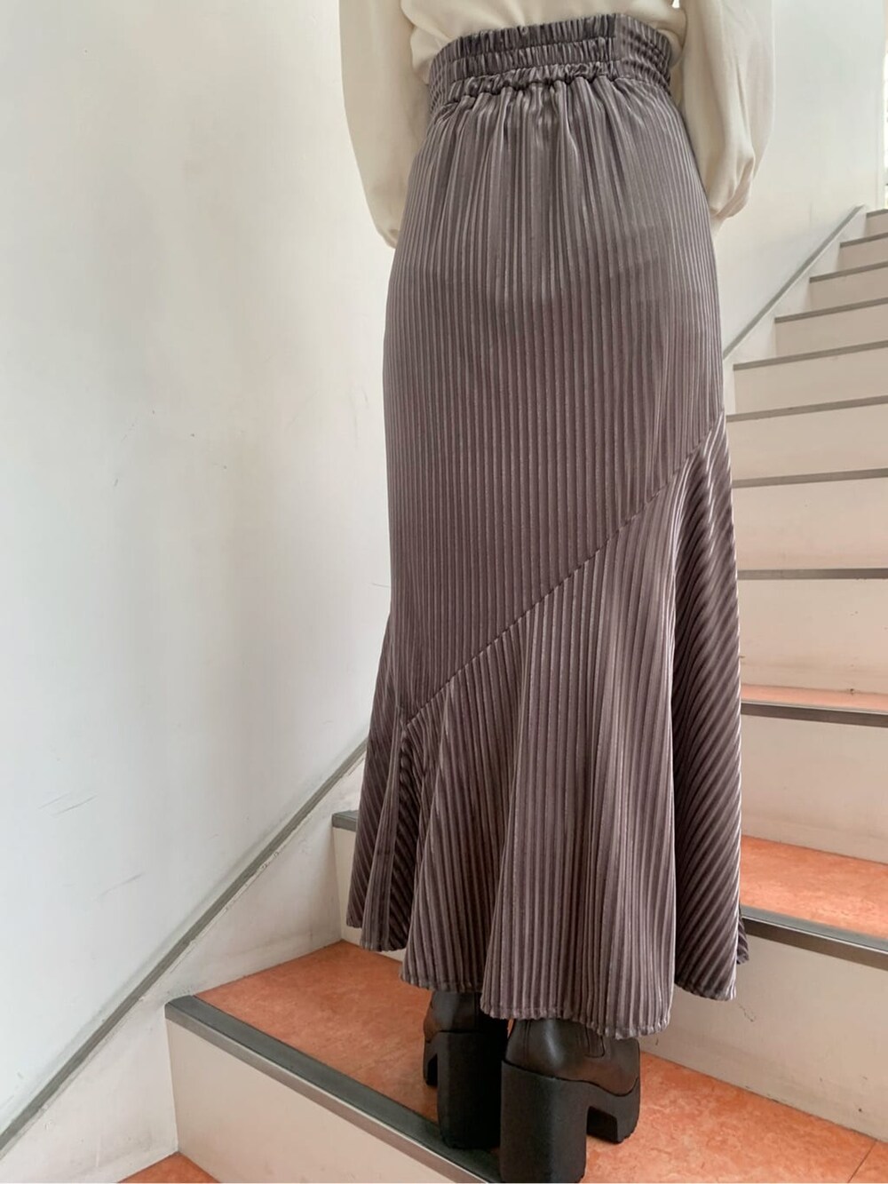 ホワイト系のニット/セーター、ブラウン系のブーツ、ベージュ系のスカートを着用したレディースの秋コーディネートの8枚目の写真