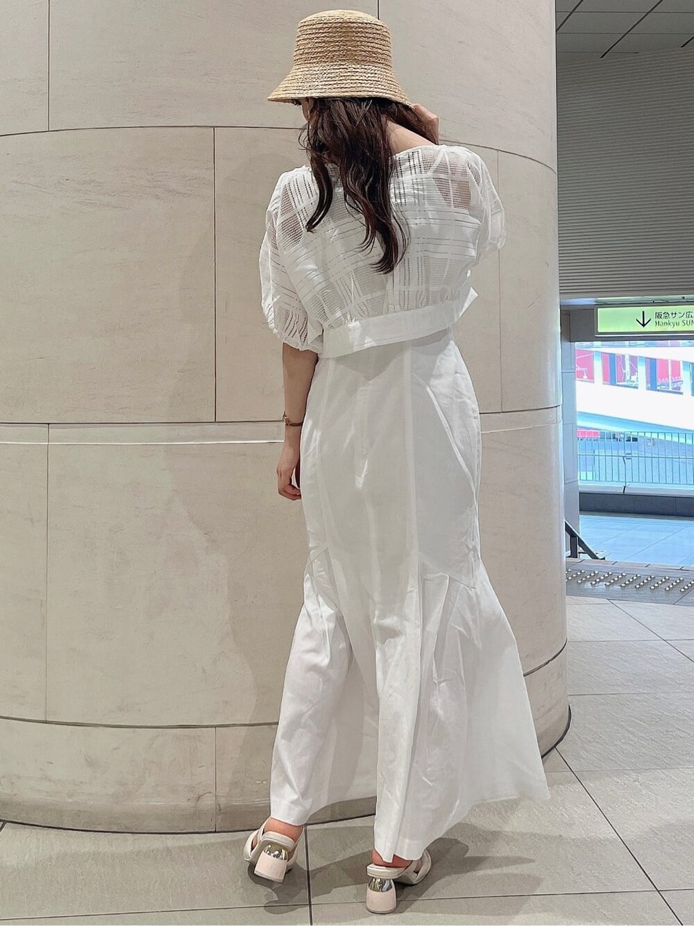 ホワイト系のワンピース、ホワイト系のサンダル、ベージュ系のハットを着用したレディースの夏コーディネートの3枚目の写真