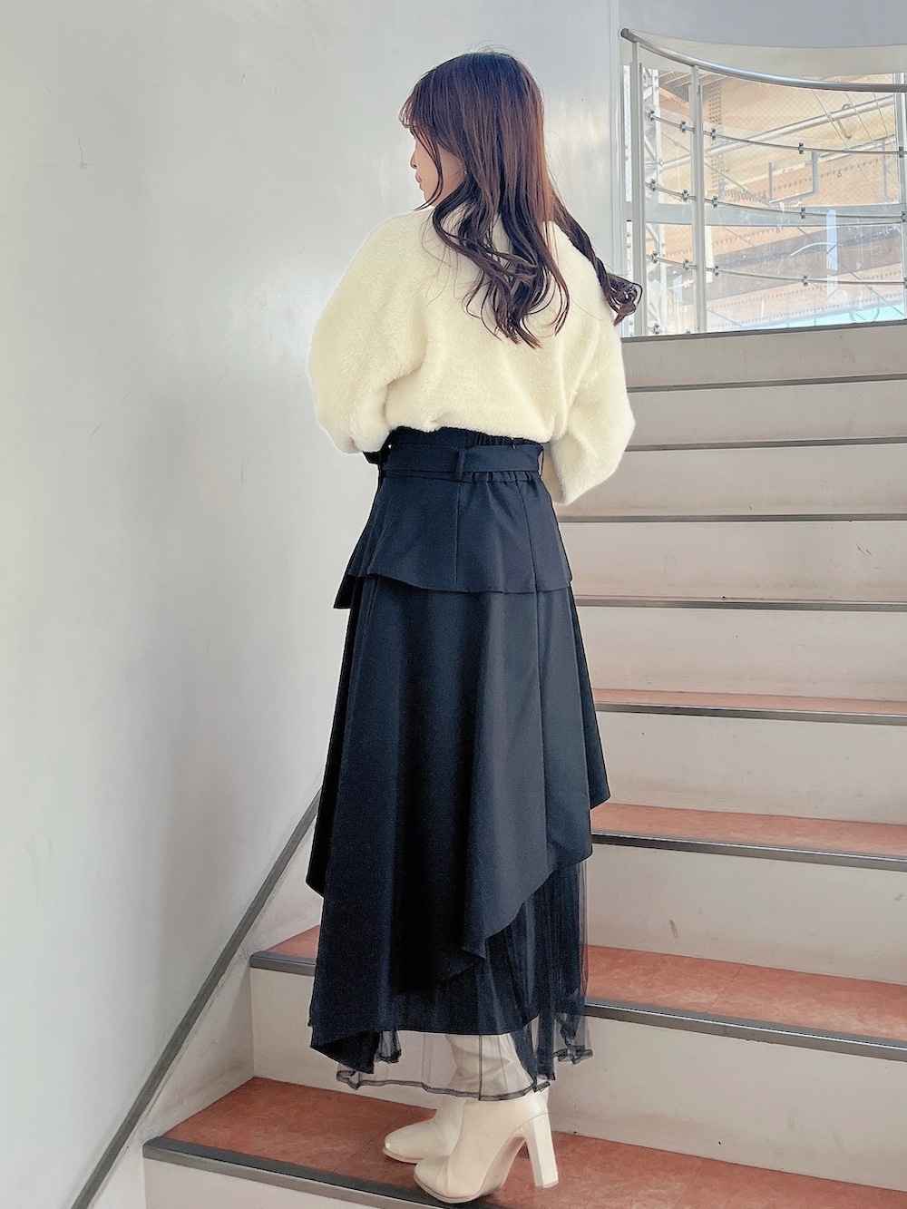 ホワイト系のブーツ、ブラック系のスカート、ホワイト系のニット/セーターを着用したレディースの秋コーディネートの5枚目の写真