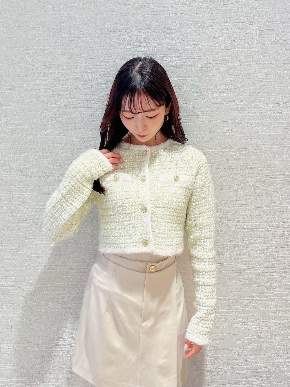 グリーン系のノーカラージャケット、ホワイト系のブーツ、ホワイト系のスカートを着用したレディースの冬コーディネートの6枚目の写真