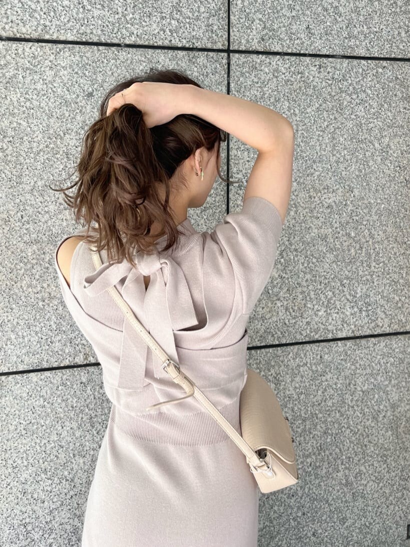 ピンク系のワンピース、ブラック系のブーツ、ホワイト系のショルダーバッグを着用したレディースの冬コーディネートの6枚目の写真