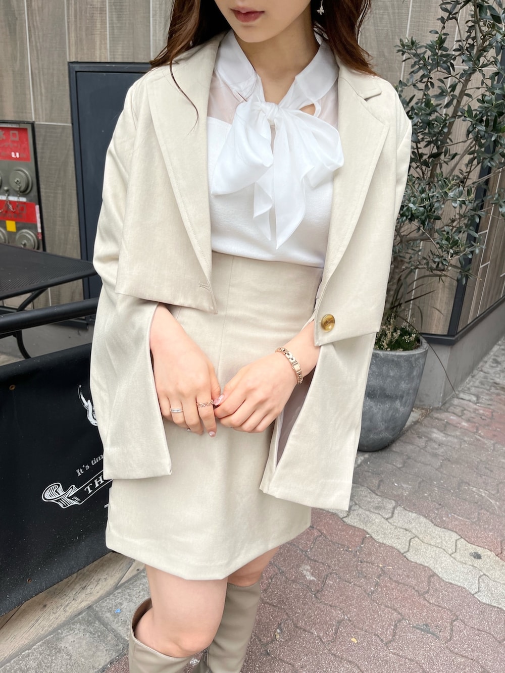 ベージュ系のテーラードジャケット、ホワイト系のニット/セーター、ベージュ系のスカートを着用したレディースの冬コーディネートの10枚目の写真