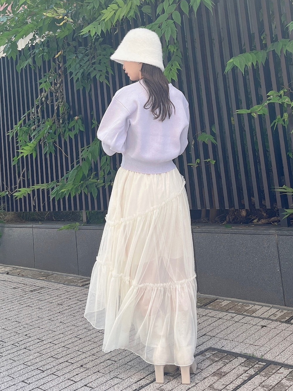 パープル系のカーディガン/ボレロ、ホワイト系のスカート、ホワイト系のブーツを着用したレディースの夏コーディネートの3枚目の写真