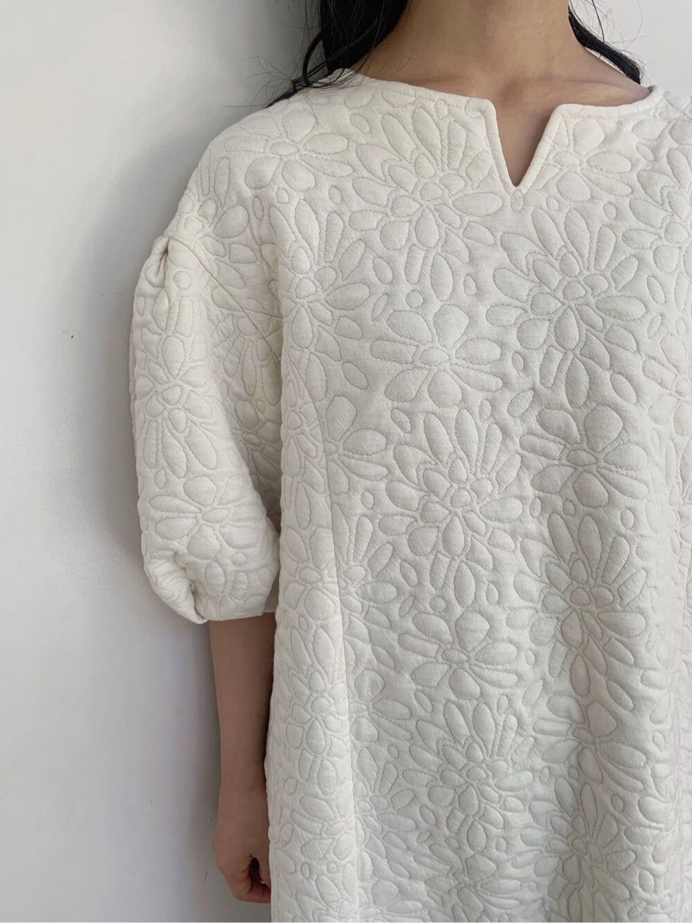 ホワイト系のチュニック、ベージュ系のショルダーバッグ、ベージュ系のブーツを着用したレディースの秋コーディネートの10枚目の写真