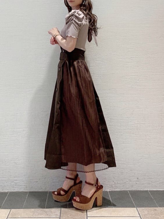 ブラウン系のサンダル、ブラウン系のスカート、ベージュ系のTシャツ/カットソーを着用したレディースの夏コーディネートの3枚目の写真