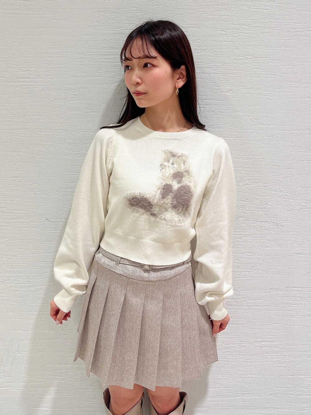 ホワイト系のニット/セーター、ベージュ系のスカート、ベージュ系のブーツを着用したレディースの冬コーディネートの9枚目の写真