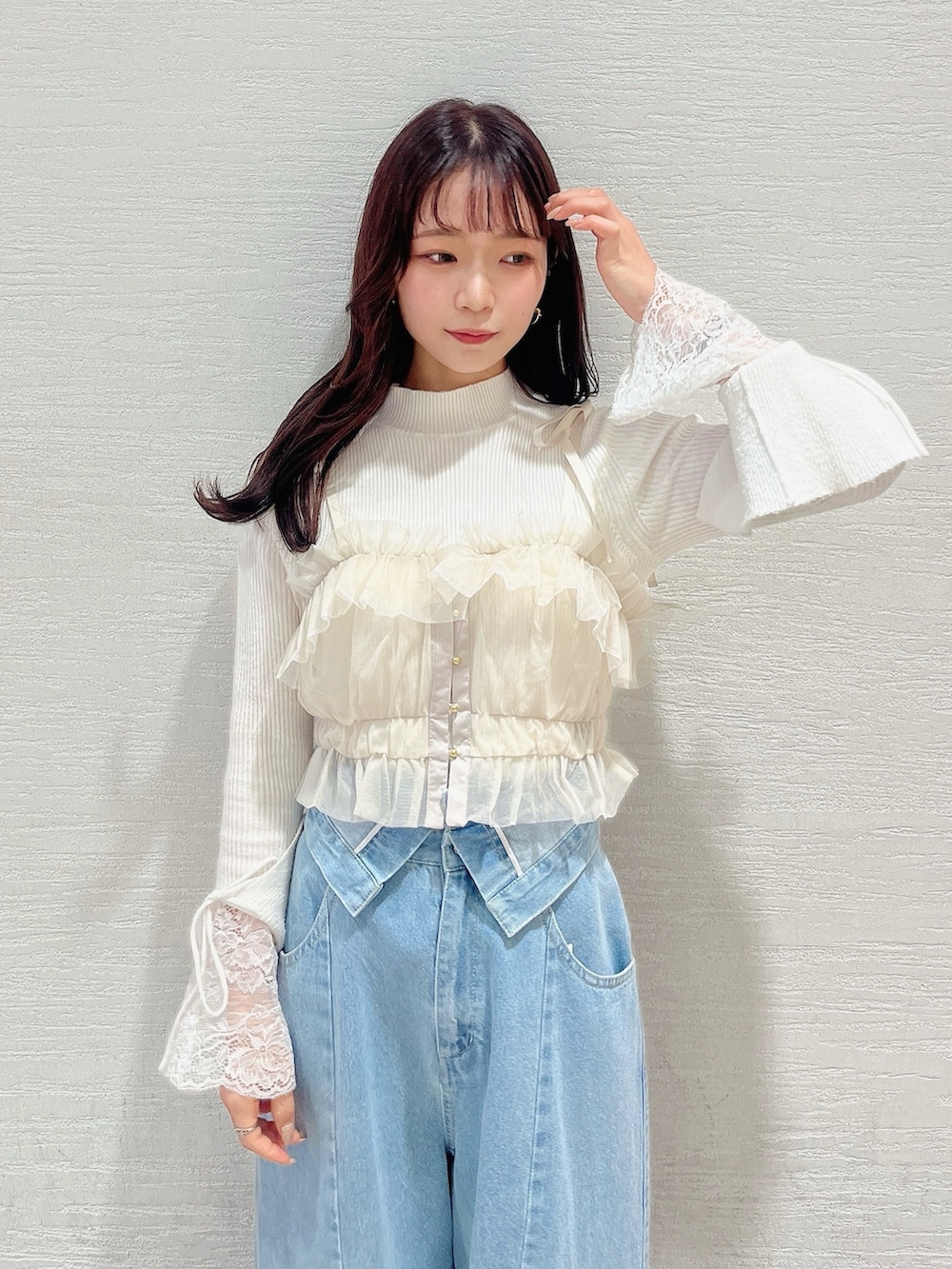 ベージュ系のブーツ、ブルー系のデニムパンツ、ベージュ系のキャミソールを着用したレディースの冬コーディネートの6枚目の写真