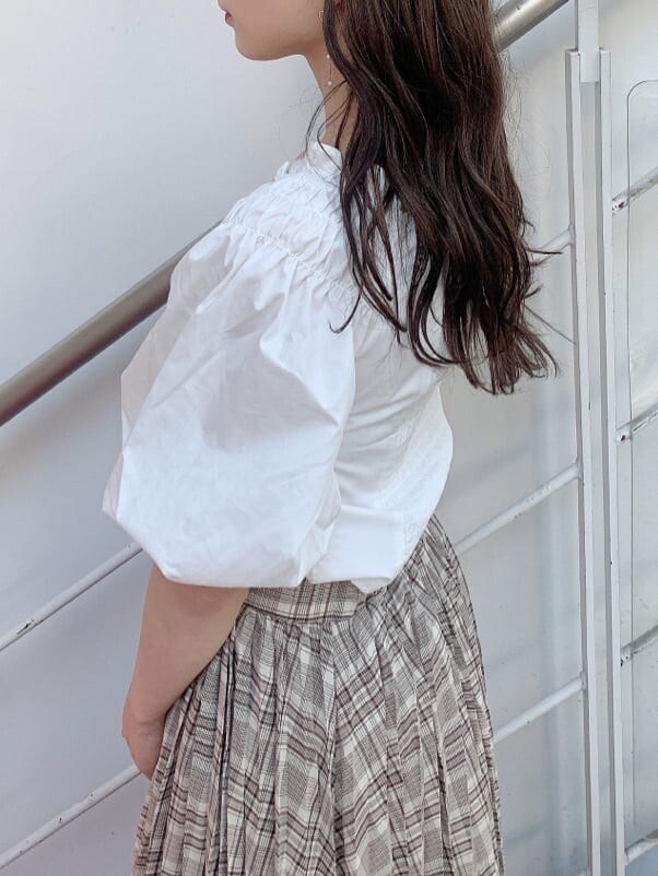 ホワイト系のシャツ/ブラウス、ベージュ系のスカート、ホワイト系のパンプスを着用したレディースの夏コーディネートの6枚目の写真