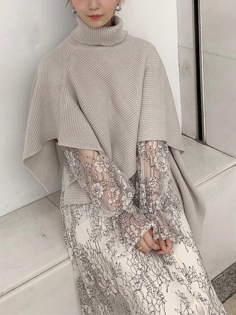 ホワイト系のワンピース、ベージュ系のニット/セーター、ホワイト系のパンプスを着用したレディースの秋コーディネートの8枚目の写真