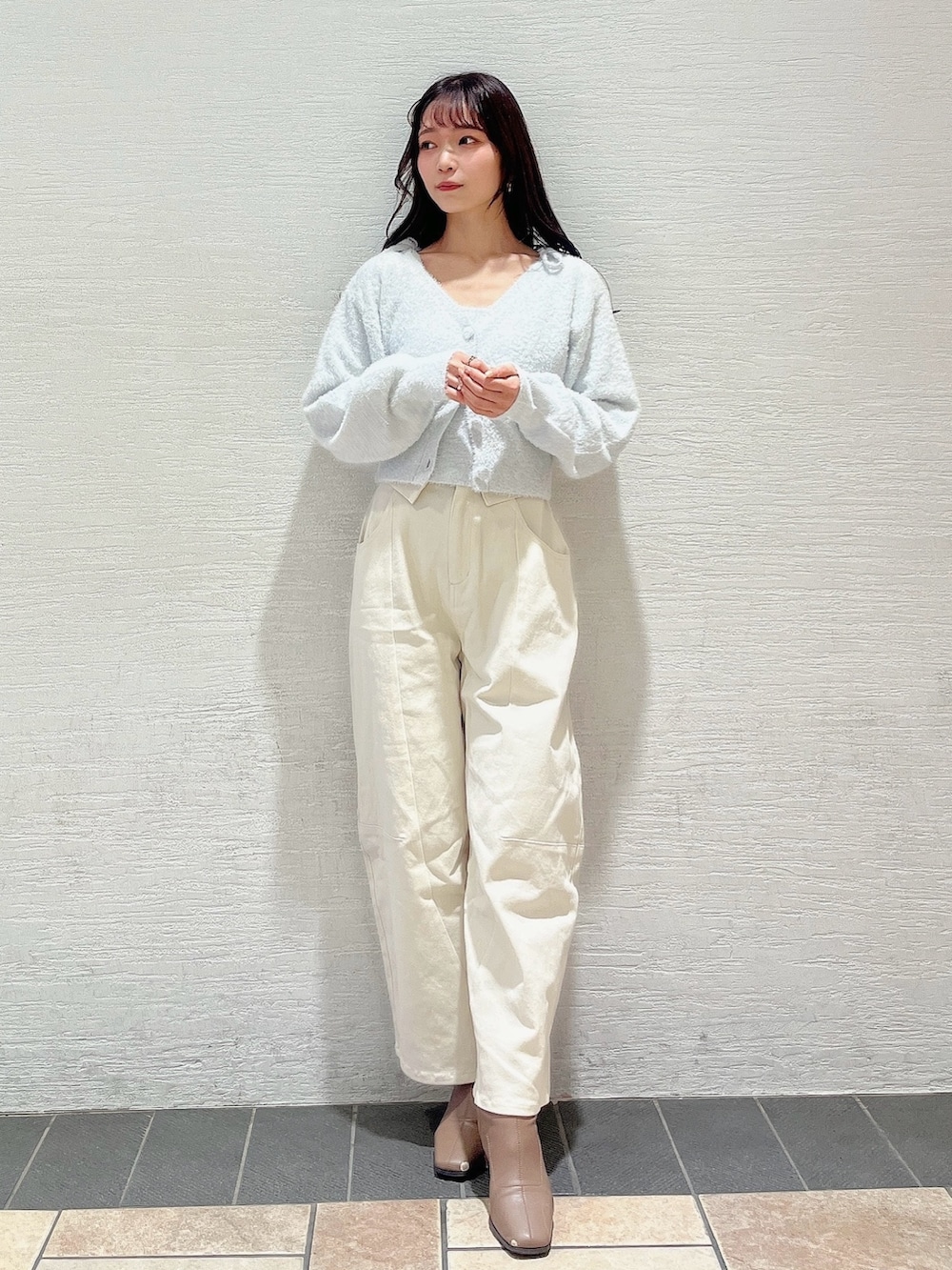 グレー系のキャミソール、グレー系のカーディガン/ボレロ、ホワイト系のデニムパンツを着用したレディースの冬コーディネートの5枚目の写真