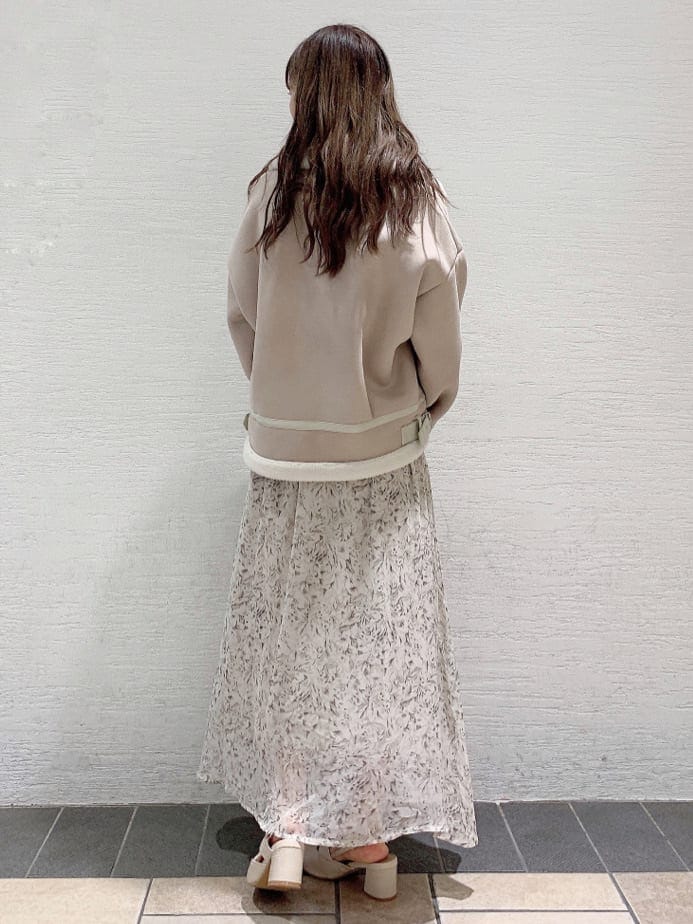 ホワイト系のブルゾン、ホワイト系のワンピース、ホワイト系のパンプスを着用したレディースの夏コーディネートの3枚目の写真