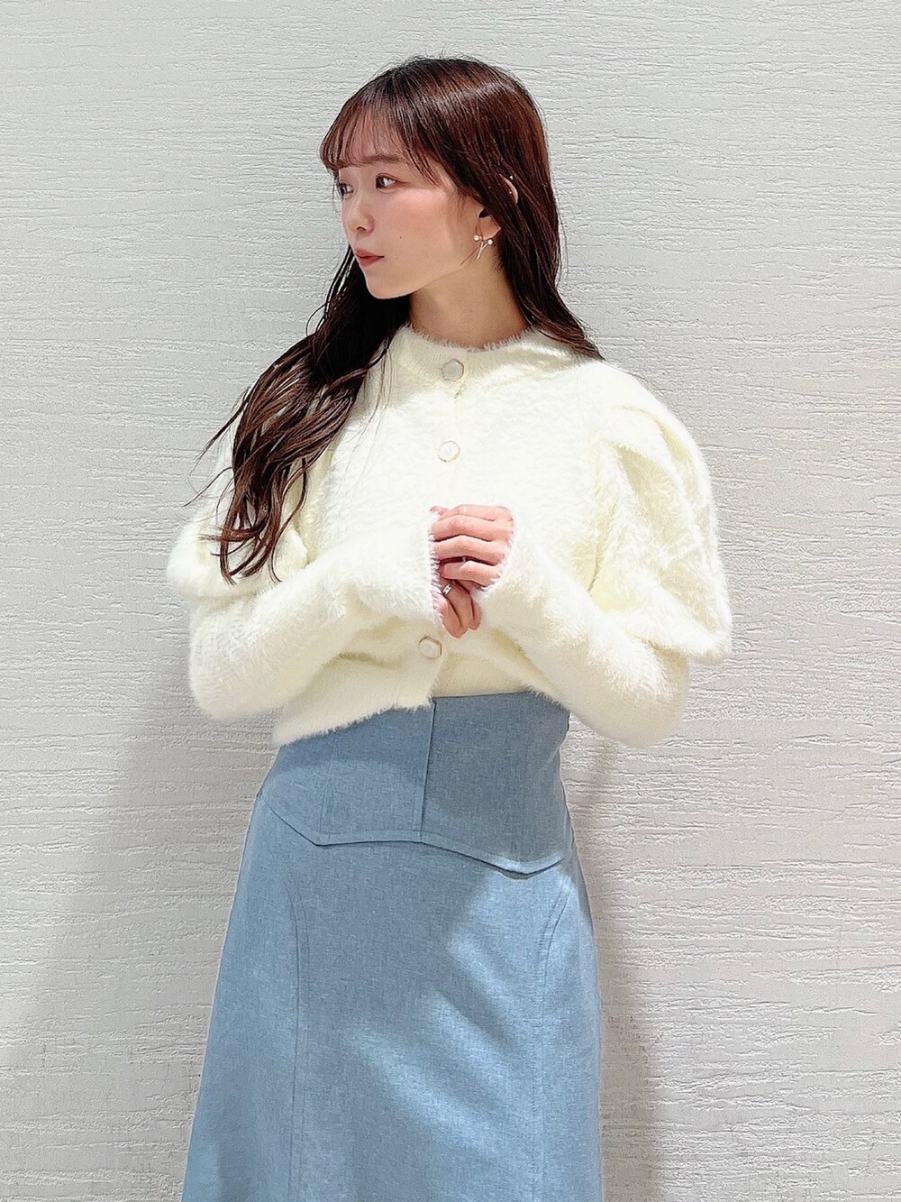 ホワイト系のニット/セーター、ブルー系のスカート、ベージュ系のブーツを着用したレディースの冬コーディネートの4枚目の写真