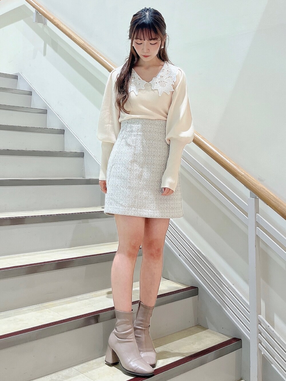 ホワイト系のニット/セーター、ホワイト系のスカート、ベージュ系のブーツを着用したレディースの冬コーディネートの2枚目の写真