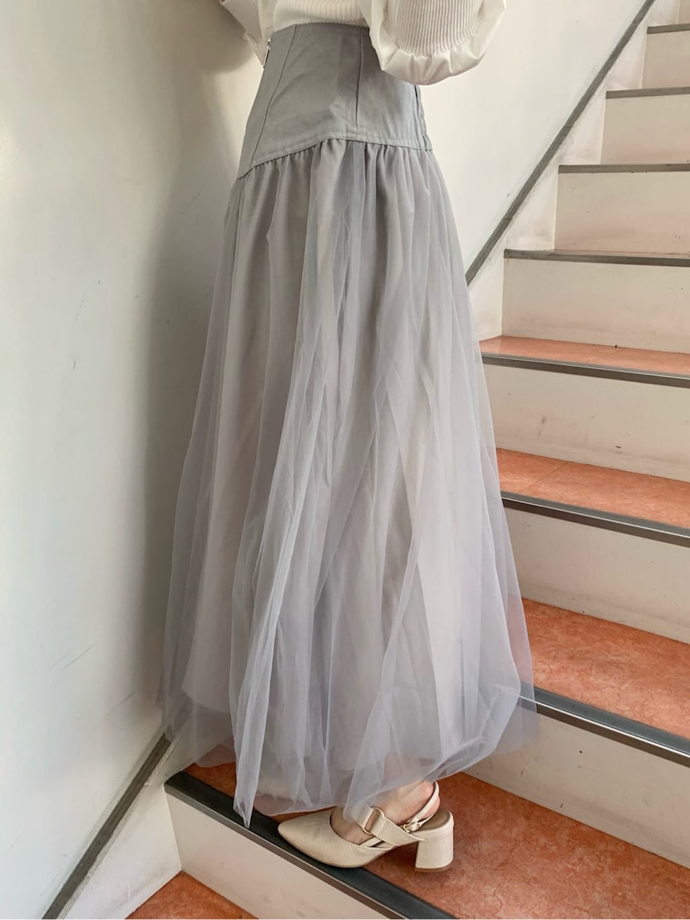 グレー系のスカート、ホワイト系のパンプス、ホワイト系のニット/セーターを着用したレディースの秋コーディネートの8枚目の写真