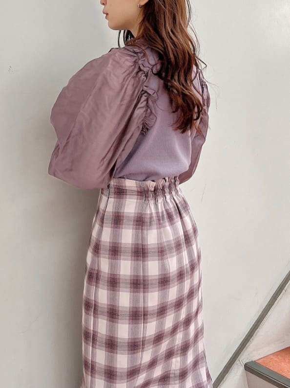 ブラック系のブーツ、パープル系のニット/セーター、パープル系のスカートを着用したレディースの冬コーディネートの5枚目の写真