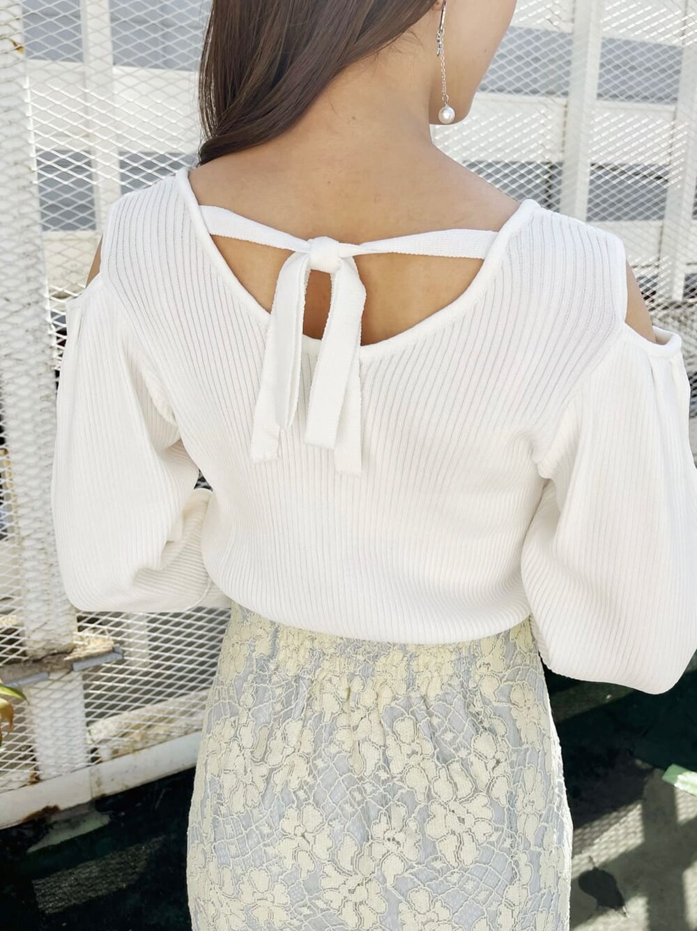 ブルー系のスカート、ホワイト系のニット/セーター、グレー系のパンプスを着用したレディースの春コーディネートの7枚目の写真