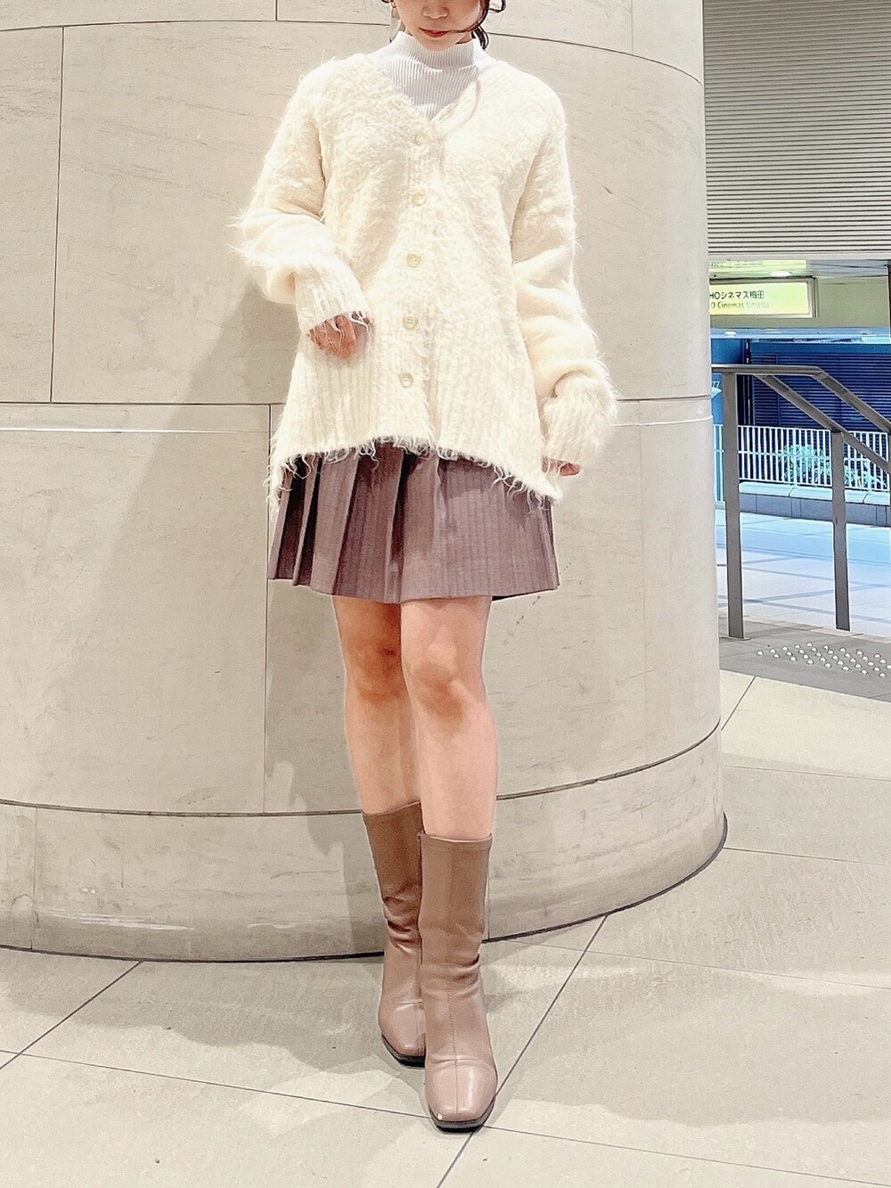 ホワイト系のニット/セーター、ホワイト系のカーディガン/ボレロ、ベージュ系のブーツを着用したレディースの冬コーディネートの2枚目の写真
