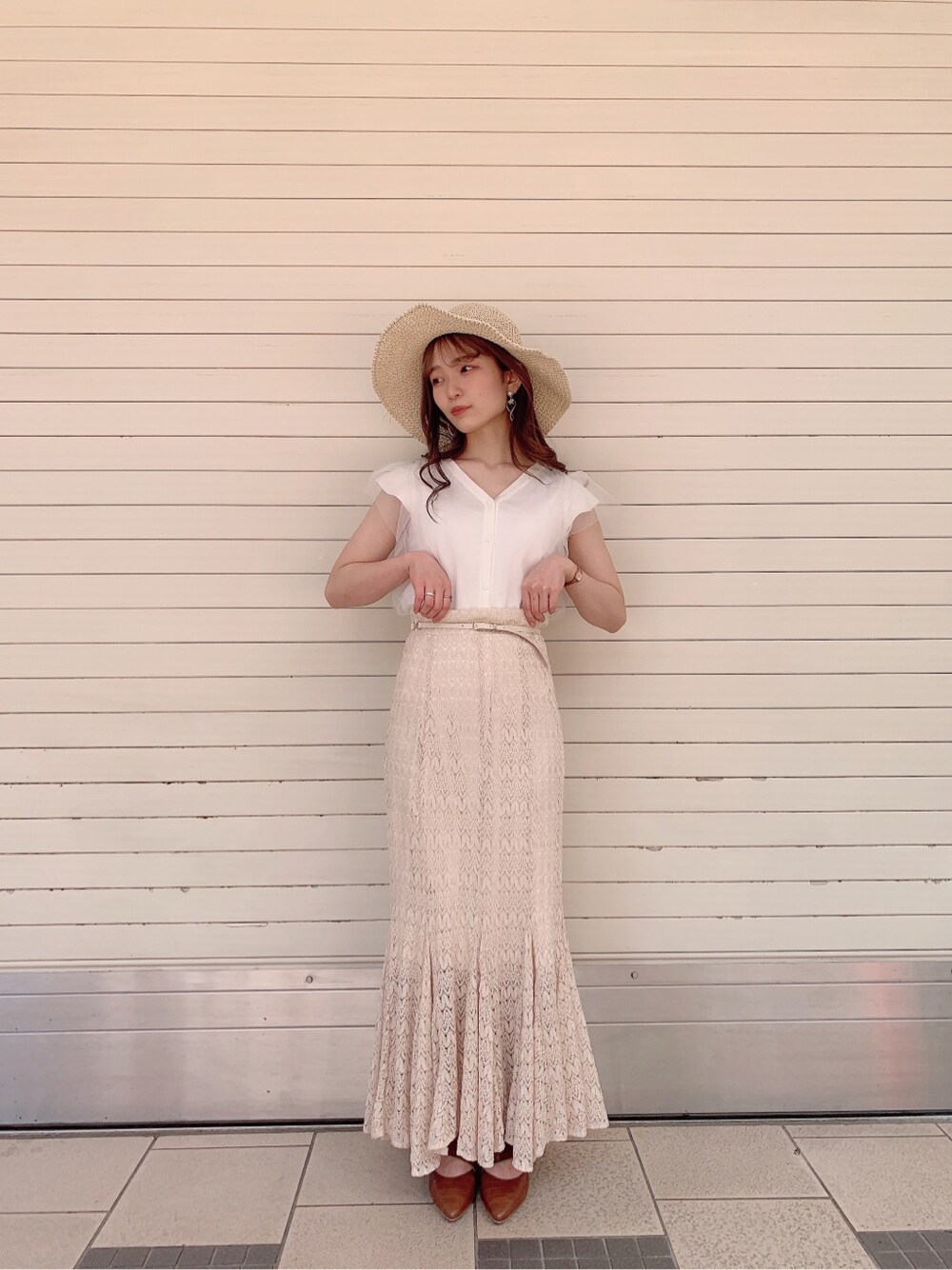 ホワイト系のスカート、ブラウン系のパンプス、ホワイト系のニット/セーターを着用したレディースの春コーディネートの2枚目の写真