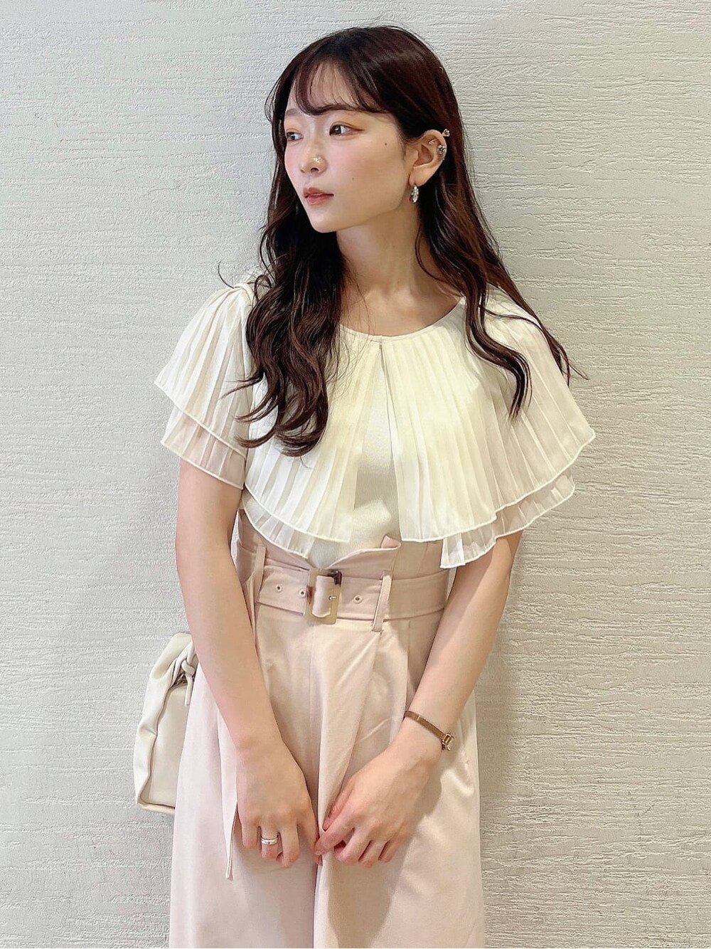 ベージュ系のその他パンツ、ホワイト系のサンダル、ホワイト系のニット/セーターを着用したレディースの夏コーディネートの4枚目の写真