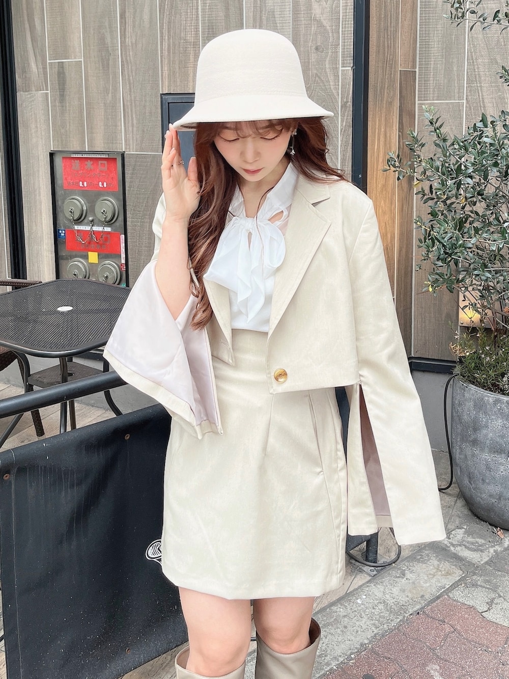 ベージュ系のテーラードジャケット、ホワイト系のニット/セーター、ベージュ系のスカートを着用したレディースの冬コーディネートの5枚目の写真