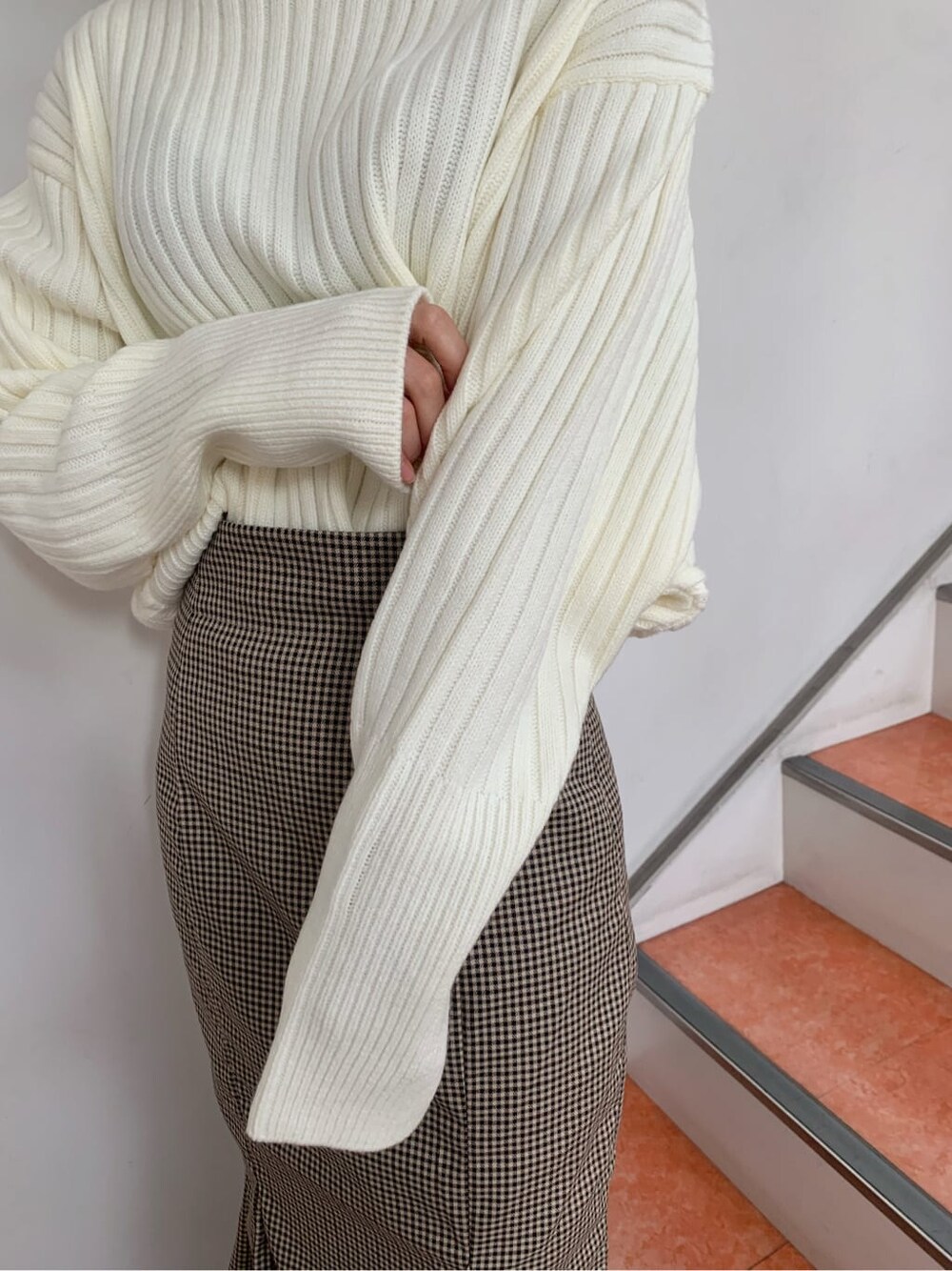 ブラウン系のブーツ、ブラウン系のスカート、ホワイト系のニット/セーターを着用したレディースの秋コーディネートの8枚目の写真