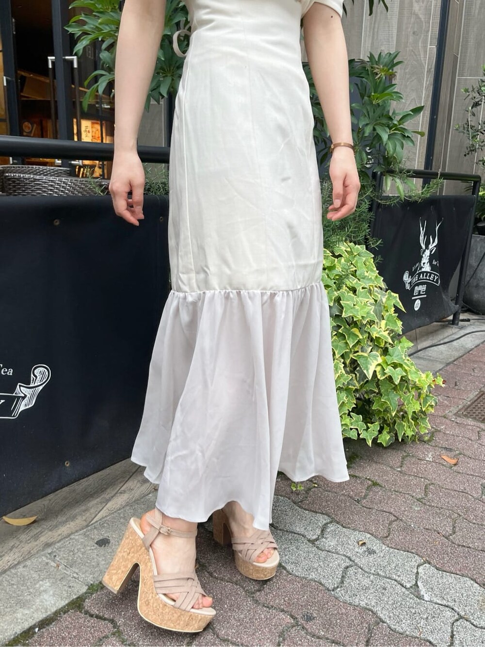 ベージュ系のサンダル、ホワイト系のスカート、ホワイト系のTシャツ/カットソーを着用したレディースの春コーディネートの8枚目の写真