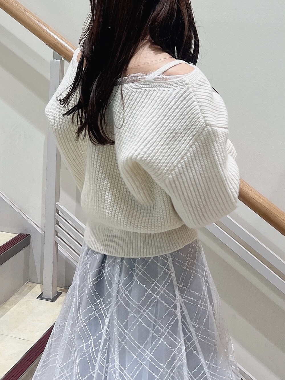 ホワイト系のニット/セーター、グレー系のスカート、ベージュ系のブーツを着用したレディースの冬コーディネートの8枚目の写真