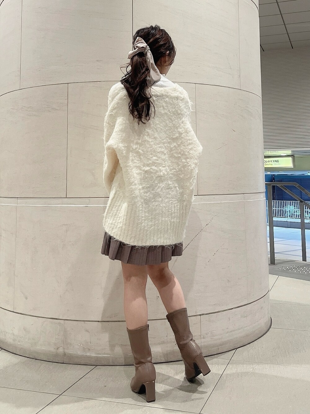 ホワイト系のニット/セーター、ホワイト系のカーディガン/ボレロ、ベージュ系のブーツを着用したレディースの冬コーディネートの4枚目の写真