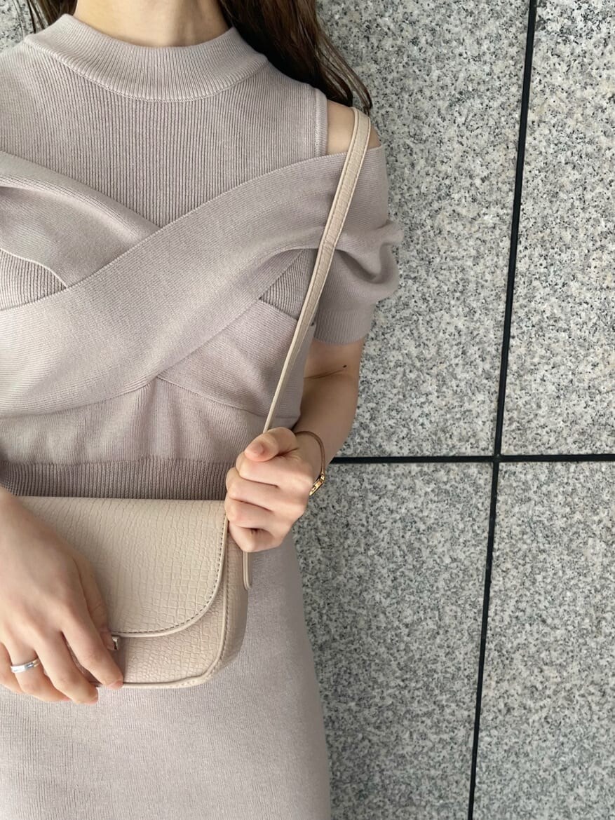 ピンク系のワンピース、ブラック系のブーツ、ホワイト系のショルダーバッグを着用したレディースの冬コーディネートの7枚目の写真