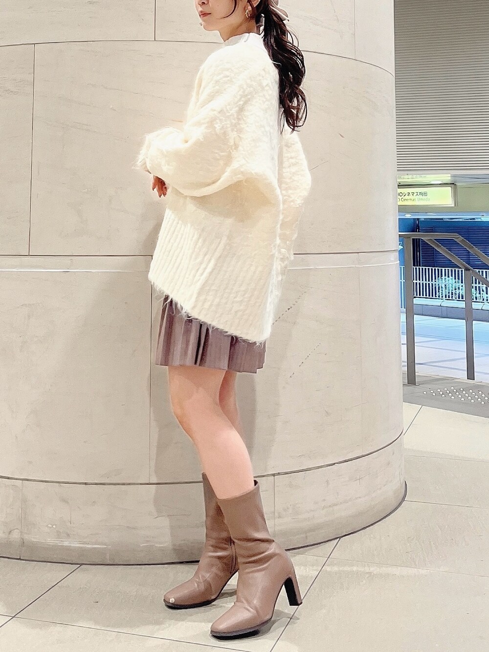 ホワイト系のニット/セーター、ホワイト系のカーディガン/ボレロ、ベージュ系のブーツを着用したレディースの冬コーディネートの3枚目の写真