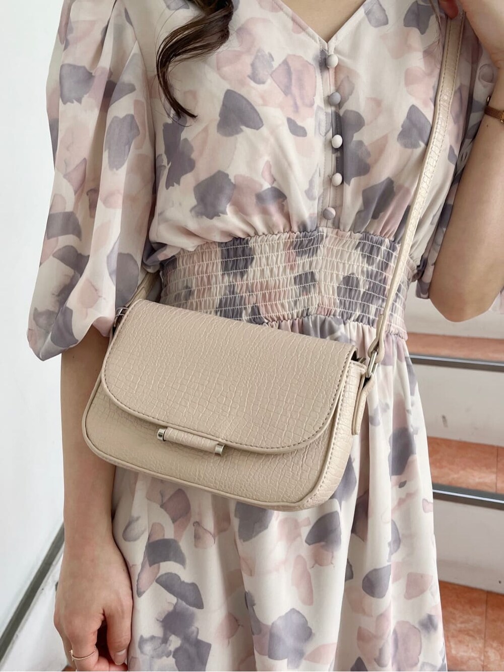 ピンク系のワンピース、ホワイト系のパンプス、ベージュ系のショルダーバッグを着用したレディースの春コーディネートの10枚目の写真