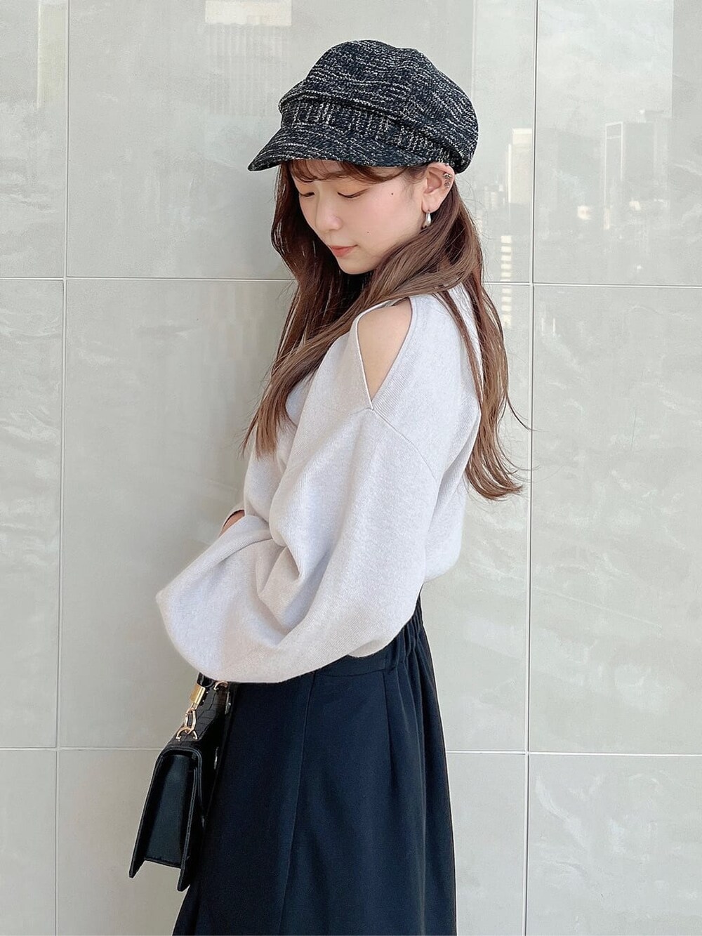 グレー系のニット/セーター、ブラック系のスカート、ブラック系のパンプスを着用したレディースの夏コーディネートの6枚目の写真