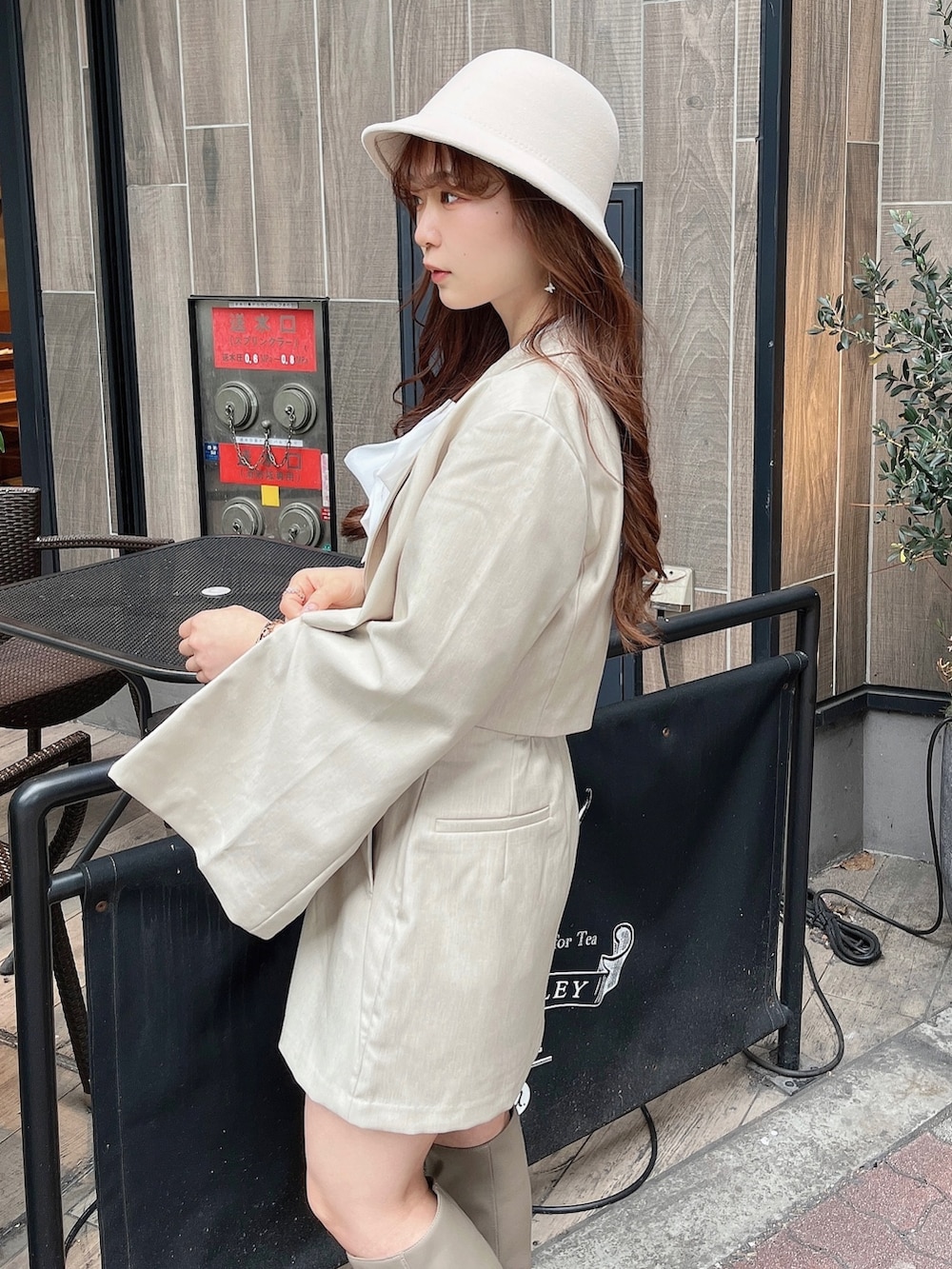 ベージュ系のテーラードジャケット、ホワイト系のニット/セーター、ベージュ系のスカートを着用したレディースの冬コーディネートの7枚目の写真