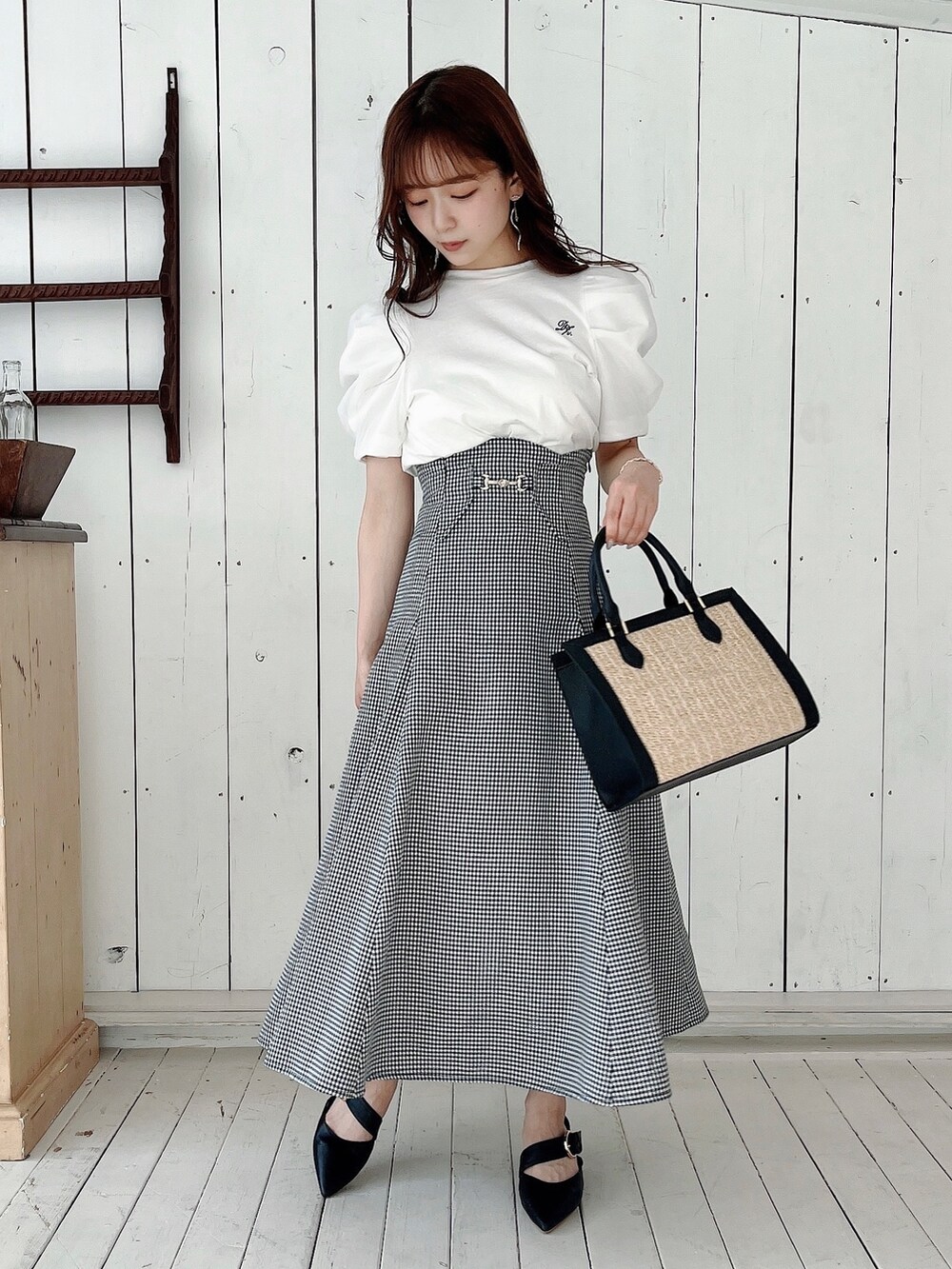 ホワイト系のTシャツ/カットソー、ブラック系のスカート、ブラック系のパンプスを着用したレディースの春コーディネートの8枚目の写真