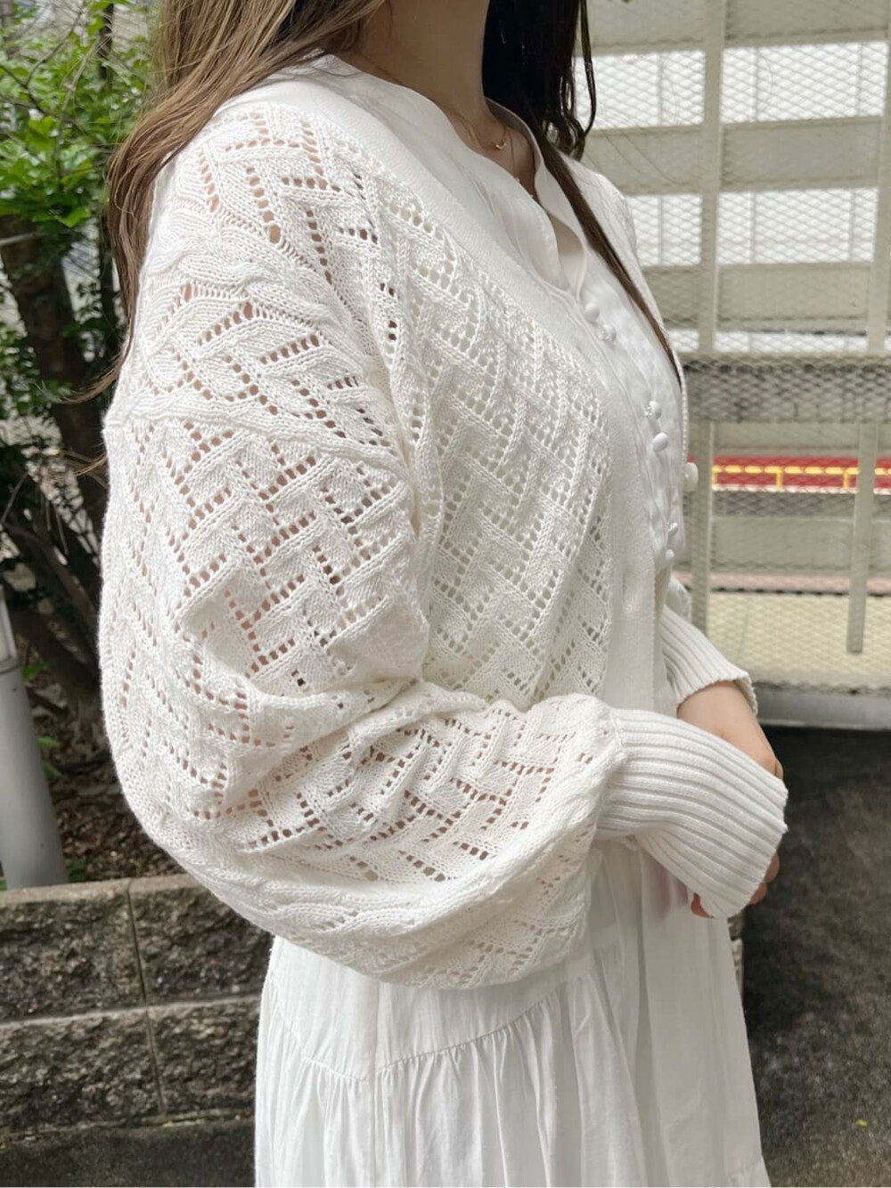 ホワイト系のワンピース、ベージュ系のサンダル、ホワイト系のカーディガン/ボレロを着用したレディースの春コーディネートの3枚目の写真